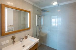 a bathroom with a sink and a shower with a mirror at Greim 15 --- Apartment mit Pool und Fernsicht 30m2 