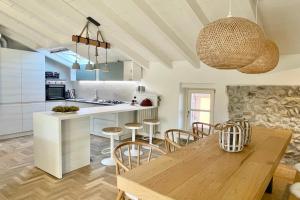 a kitchen and dining room with a wooden table and chairs at Borgo dei Sogni - Unique Loft - Lago di Garda in San Felice del Benaco