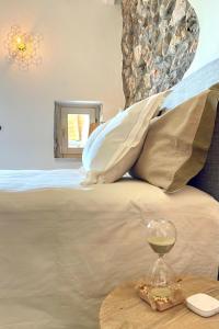 una copa de vino en una mesa junto a la cama en Borgo dei Sogni - Unique Loft - Lago di Garda, en San Felice del Benaco