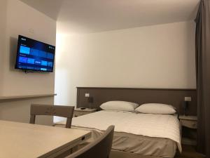 a bedroom with a bed and a flat screen tv on the wall at Hotel Italia in Sacile