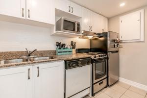 a kitchen with stainless steel appliances and white cabinets at Mountainside River Dream. Walk to slopes, tennis, bike, ski, hot tub, pool! in Blue Mountains