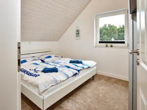 a white bedroom with a bed and a window at Nordlicht - Nordhorn in Nordhorn