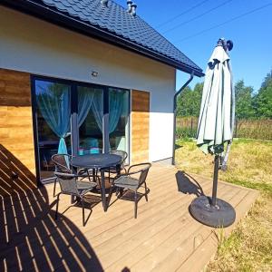 a patio with a table and chairs and an umbrella at W cieniu Szarloty in Rydułtowy