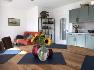 a living room with a table with a vase with a sunflower in it at Ferienhaus De Beers Huus - Holte-Spangen - a69919 in Cuxhaven