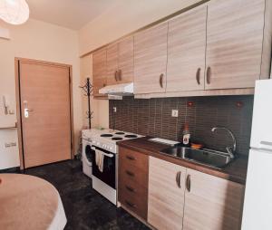 a kitchen with a sink and a stove top oven at Efrosini downtown apartment in Chalkida