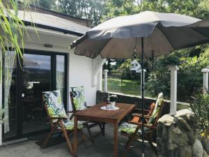 a table and chairs with an umbrella on a patio at Seeblick - Sellin in Sellin