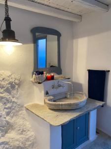 a bathroom with a sink and a mirror on a counter at Windhouses Serifos in Serifos Chora +50 photos