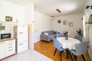 eine Küche und ein Wohnzimmer mit einem Tisch und einem Sofa in der Unterkunft Ponte Apartment in Orasac