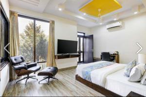 a bedroom with a large bed and a tv at ZEST DAMODAR GARH - The Stress Free Zone in Jodhpur