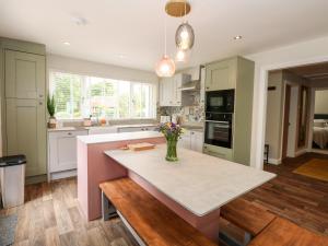a kitchen with a vase of flowers on a counter at Daisy Tree Cottage in Woodhall Spa