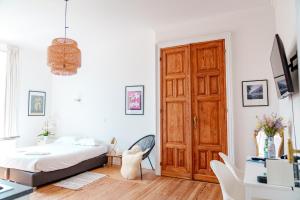 a white bedroom with a bed and a desk at Smart Appart - Gare Du Midi in Brussels