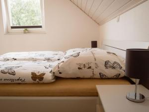 a bed with two pillows with butterflies on it at Vechtestrand - Nordhorn in Nordhorn