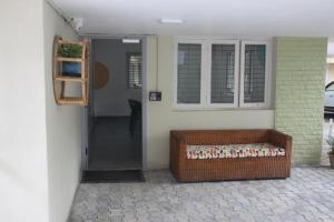 a porch with a wicker bench next to a door at Habitat15@airlines in Bengaluru