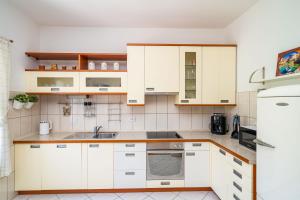 a kitchen with white cabinets and a sink at Ponte Apartment in Orasac +11 photos