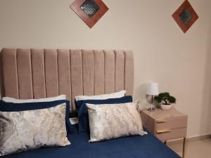 a bed with blue sheets and pillows next to a table at Rooikrans Guest House in Johannesburg