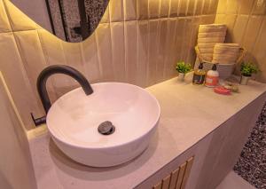 a white sink in a bathroom with a mirror at The Rooster's House in Spílion