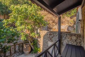 a balcony with a tree and a bench at The Rooster's House in Spílion +11 photos