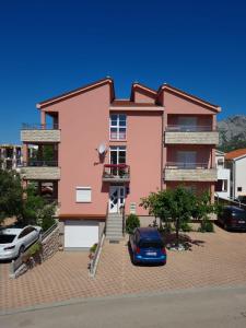 una casa rosa con un coche aparcado delante de ella en Apartments Marta en Seline