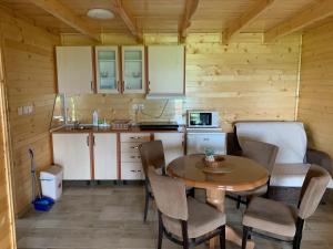 a kitchen with a table and chairs in a room at Boja zalaska - drveni apartman in Jagodina