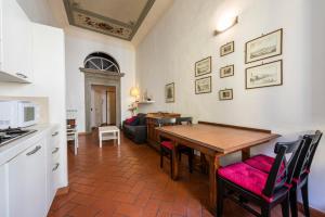 a kitchen and dining room with a wooden table at Casa Ghibellina by Mmega in Florence +5 photos
