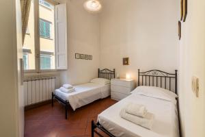 a bedroom with two beds and a window at Casa Ghibellina by Mmega in Florence