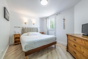 a bedroom with a bed and a tv on a dresser at Hotel Le Clos Fleuri in Le Palais
