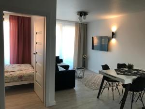 a living room with a bed and a dining room at BALTIC SUN in Sztutowo +11 photos