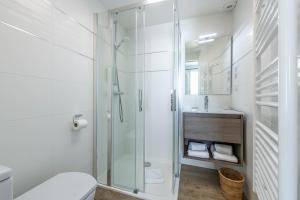 a bathroom with a shower and a toilet and a sink at Hotel Le Clos Fleuri in Le Palais