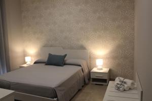 ein Schlafzimmer mit einem Bett und zwei Tischen mit Lampen in der Unterkunft Albadorata in Praia a Mare