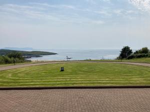 a large grassy field with a view of the water at Millfarm House in Killybegs