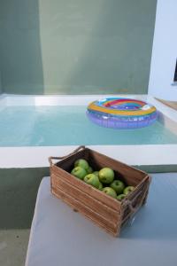 a wooden crate of apples on a table with a plate at Dandy Villas Tsagkarada-Green Apple-Jacuzzi-Sea View in Tsagarada