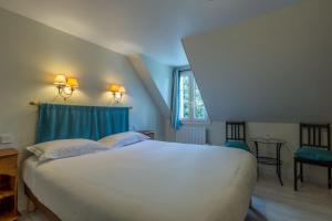 a bedroom with a large white bed and a window at Hotel Le Clos Fleuri in Le Palais