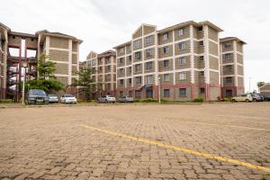 ein Parkplatz vor einem großen Gebäude in der Unterkunft Bonaventure Apartment in Kisumu