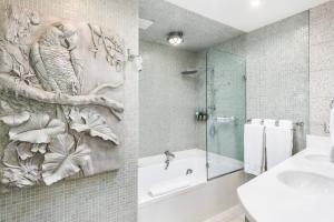 La salle de bains est pourvue d'un lavabo et d'une baignoire avec une peinture murale. dans l'établissement National Hotel, An Adult Only Oceanfront Resort, à Miami Beach