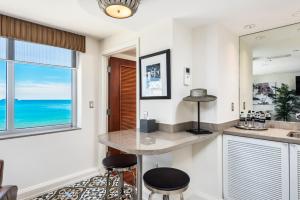 a kitchen with a counter and two stools and a window at National Hotel, An Adult Only Oceanfront Resort in Miami Beach