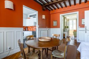 een eetkamer met oranje muren en een tafel en stoelen bij Veeve - Beam Me Up in Parijs