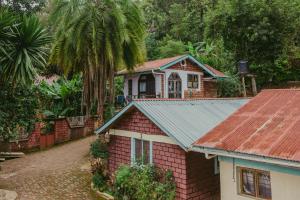 Lushoto的住宿－Lushoto views cottage，红砖房子,有锈色的锡屋顶
