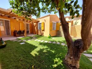 a yard with a tree and a house at villa Sara in Teulada