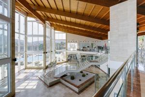 an open lobby with a staircase and large windows at Alua Village Fuerteventura - All Inclusive in Playa Jandia