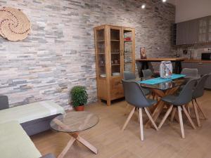een keuken met een tafel en stoelen en een bakstenen muur bij villa Sara in Teulada