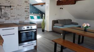 a kitchen and living room with a couch and a table at Apartman Megi & studio apartman Tomi - SELF CHECK IN in Krapina