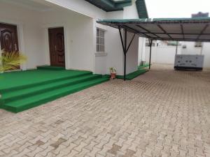 eine Terrasse mit grünem Boden in einem Gebäude in der Unterkunft Vintz Apartments in Abuja