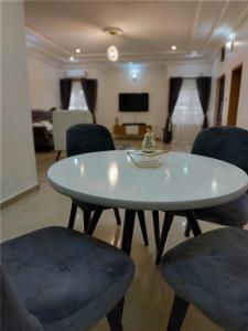 einen weißen Tisch und Stühle im Wohnzimmer in der Unterkunft Vintz Apartments in Abuja