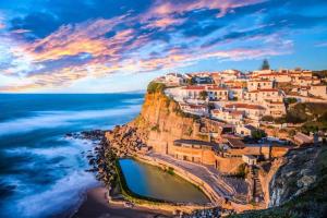 a village on a cliff next to the ocean at Villa Cielo - Family House in Sintra