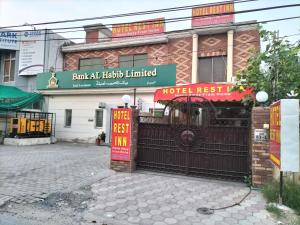 a hotel next to a building with a gate at Hotel Rest INN in Lahore