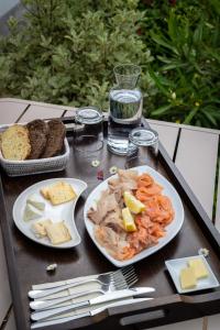 a tray with two plates of food on a table at Hotel Le Clos Fleuri in Le Palais