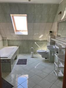 a bathroom with a tub and a toilet and a sink at Pokoje Alicja in Łeba