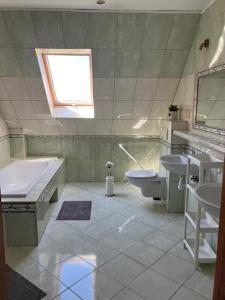 a bathroom with a tub and a toilet and a sink at Pokoje Alicja in Łeba +60 photos