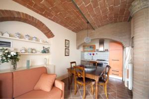una cucina e un soggiorno con tavolo e divano di Villa il Pino by VacaVilla a Lari