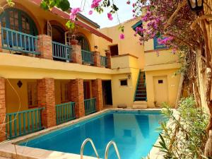 a house with a swimming pool in front of it at Principauté in Gorée